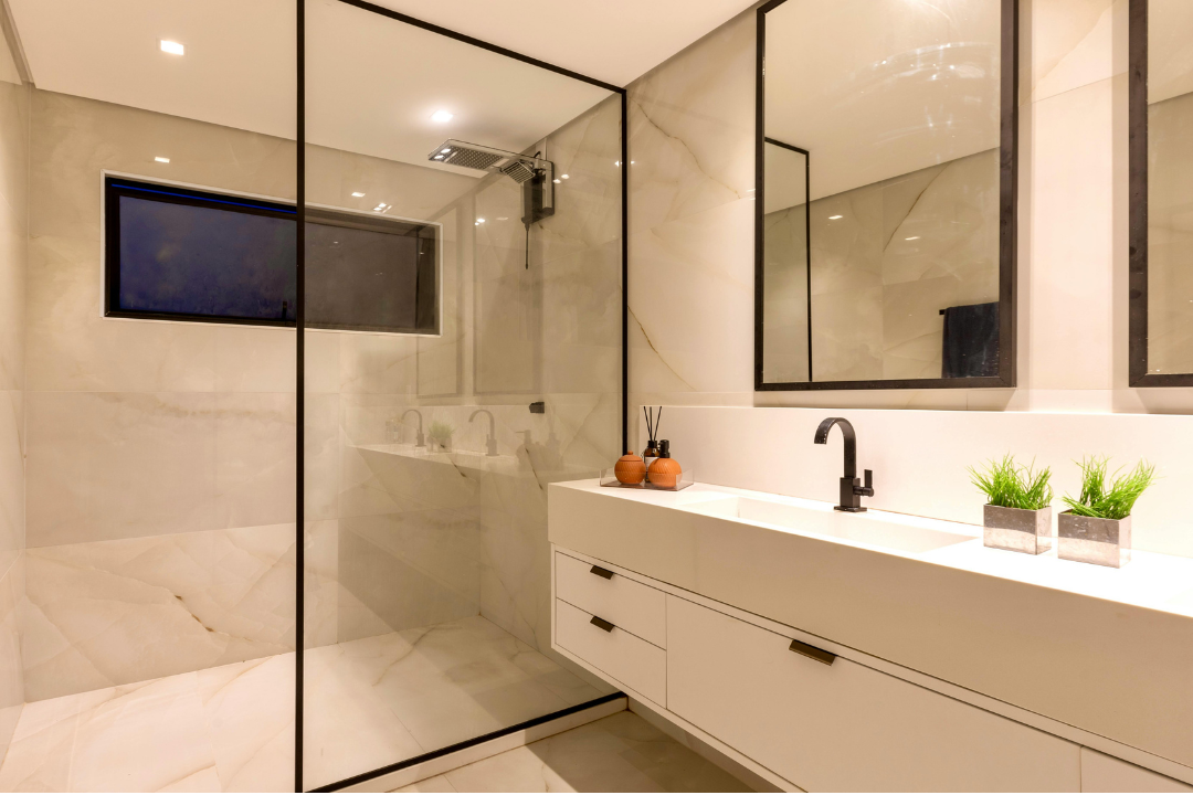 A sparkling clean bathroom with a glass shower and clear counters